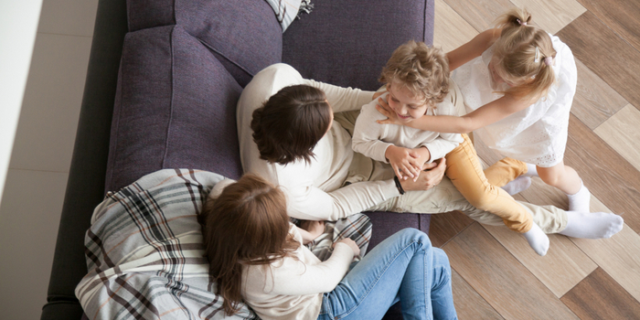 3 Man and woman with children sitting on modern sofa